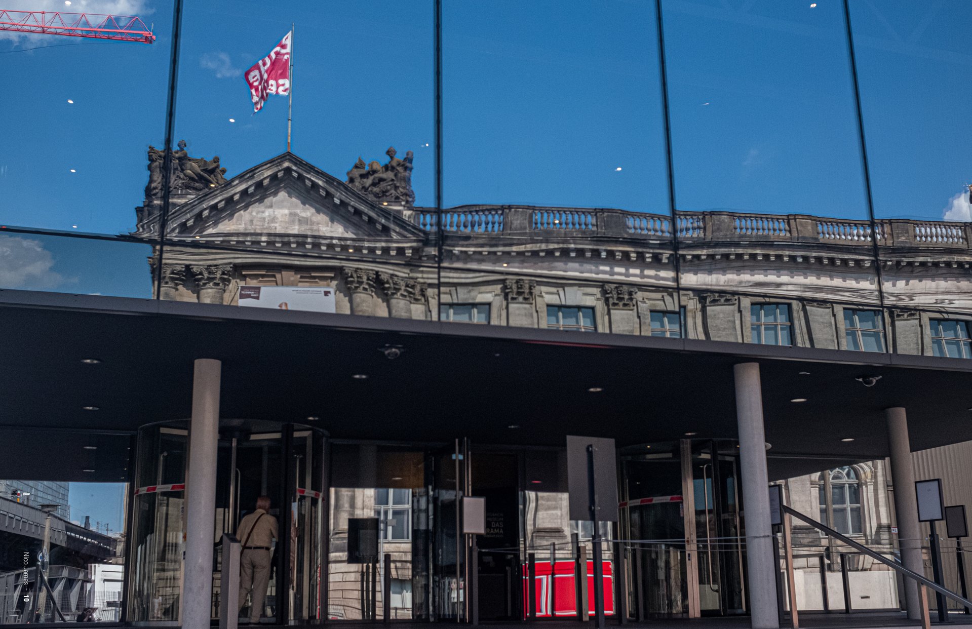 Photograph of an older building reflected in a modern building