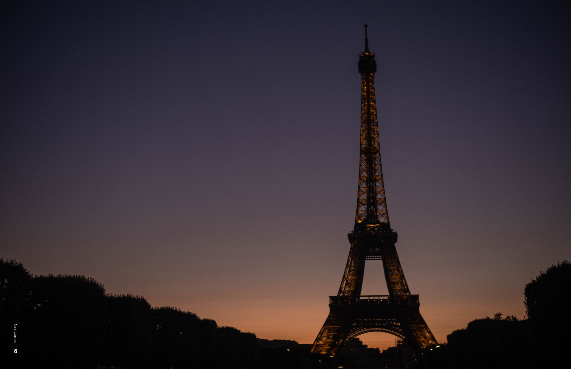 photograph of Eiffel Tower in silhouette with sun setting behind it.